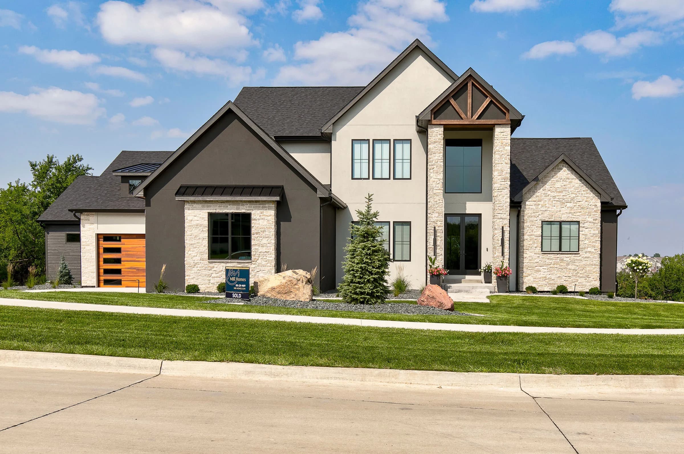 MIR Homes luxury custom build — stone and timber front elevation